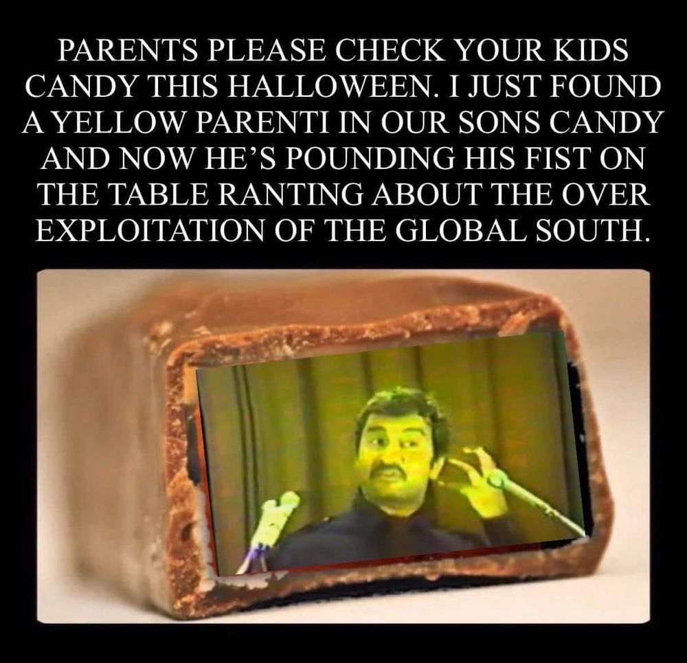 Photo of the broken open end of a chocolate covered candy bar with a yellow tinted image of Michael Parenti speaking into a microphone photoshopped inside and a caption that reads: PARENTS PLEASE CHECK YOUR KIDS CANDY THIS HALLOWEEN. I JUST FOUND A YELLOW PARENTI IN OUR SONS CANDY AND NOW HE'S POUNDING HIS FIST ON THE TABLE RANTING ABOUT THE OVER EXPLOITATION OF THE GLOBAL SOUTH.
