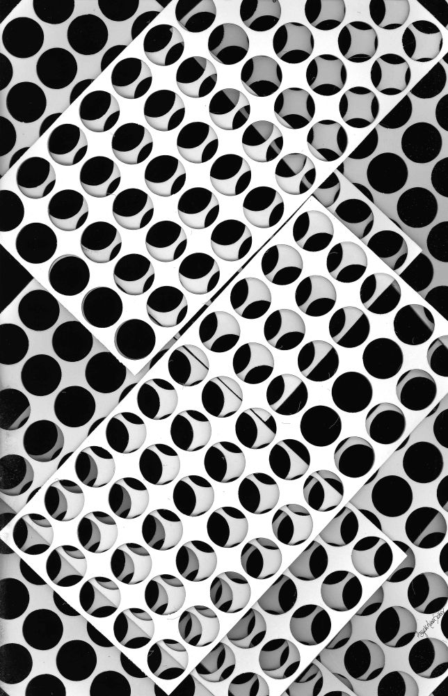 For those unfamiliar with the term, scanography is made by using a flatbed scanner to capture and create a digitized image of 3-dimensional objects. I used to have access to one at my old job and had a lot of fun scanning all sorts of things like creepy dolls, plants, holiday decorations, old gloves... It's fun to find new ways to create imagery! 

Image description: Monochrome image consisting of punched-out circles and the material surrounding the holes. Flat, rectangular sheets of this material are placed overlapping each other and at a diagonal line within the frame, creating repeated alternating black and white circular fragments. I see this image as alternating in these ways: black/white, light/dark, positive/negative, mass/void, circular/linear.