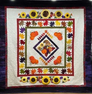 Ninigret Quilters' Fall Splendor raffle quilt. A fall-themed quilt with autumn leaves, pumpkins, and a cornucopia.