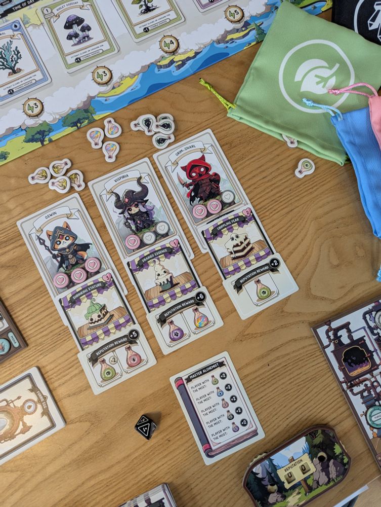 Details of the board game Apothebakery. There are cards with different adventurers and their diagnosis and the baked good required to heal them.