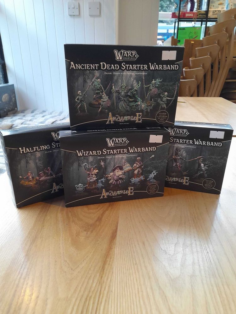 Arcworlde miniature game starter sets on a table in the Edinburgh board game shop Ancient Robot Games. The sets include a wizard starter set, halfling starter set, vampire starter set and an ancient dead starter set.