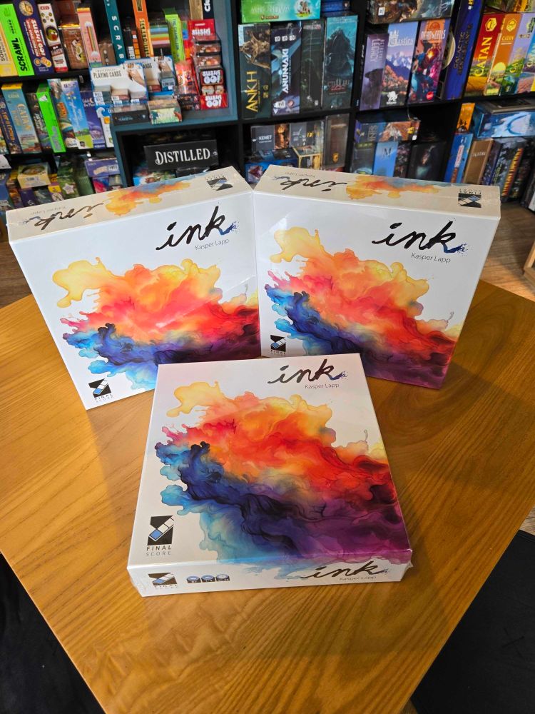 The board game Ink on a table in Ancient Robot Games board game store. The cover has an abstract colourful illustration