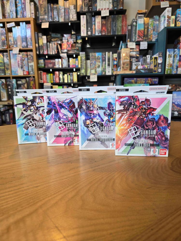 The starter sets for the card game Gundam on a table in the Edinburgh board game shop Ancient Robot Games.