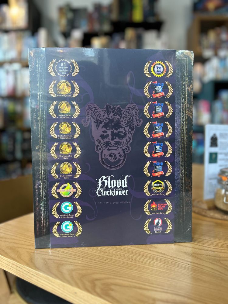 The game Blood on the Clocktower on a table in the Edinburgh board game shop Ancient Robot Games. Shelves of board games are visible in the background 