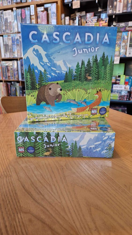 Copies of the board game Cascadia Junior on a table in the Edinburgh board game shop Ancient Robot Games. The game has illustrations of animals.