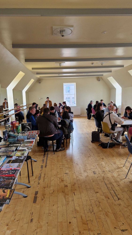 Games at Cymera festival. There are multiple tables full of people enjoying games.