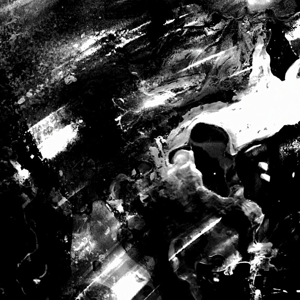 The cover art for Bolt Gun - Begotten. Honestly, I don't know how to describe it. A monochrome picture of rays of light smudged into a liquid spill?