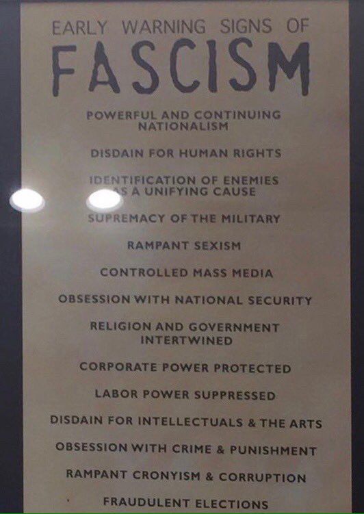 A sign listing the early signs of fascism, which include “identifying enemies as a a unifying cause”, “rampant sexism”, “controlled mass media”, “disdain for intellectuals and the arts” and “rampant cronyism and corruption “.