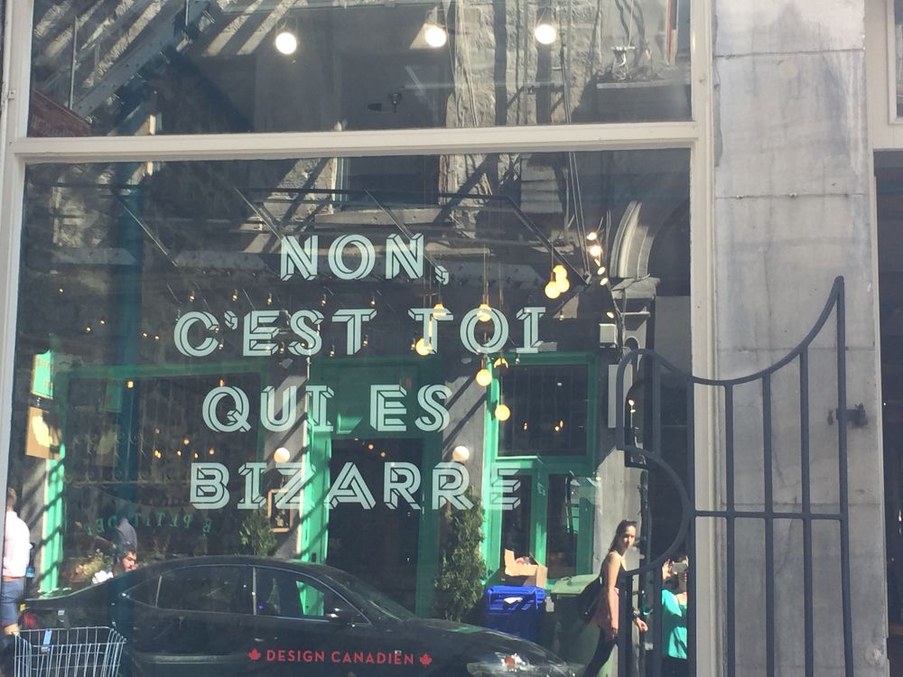 Image of a shop window in Montreal, Canada which reads “Non, c’est toi qui es bizarre”