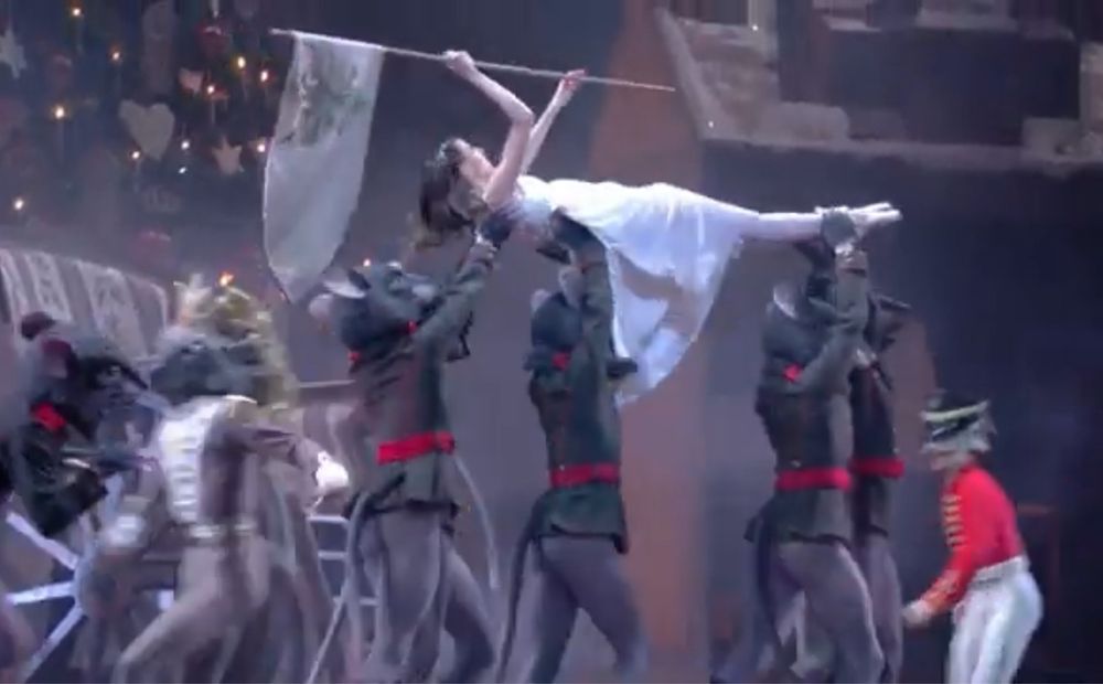 Clara du ballet Casse-Noisette tient un drapeau blanc et se fait exfiltrer par des petits rats
