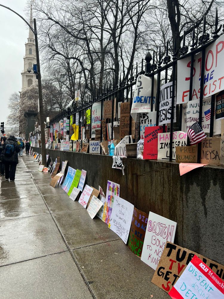 Wall of posters from Hands Off rally in gate at Old Granary Burial Ground. 