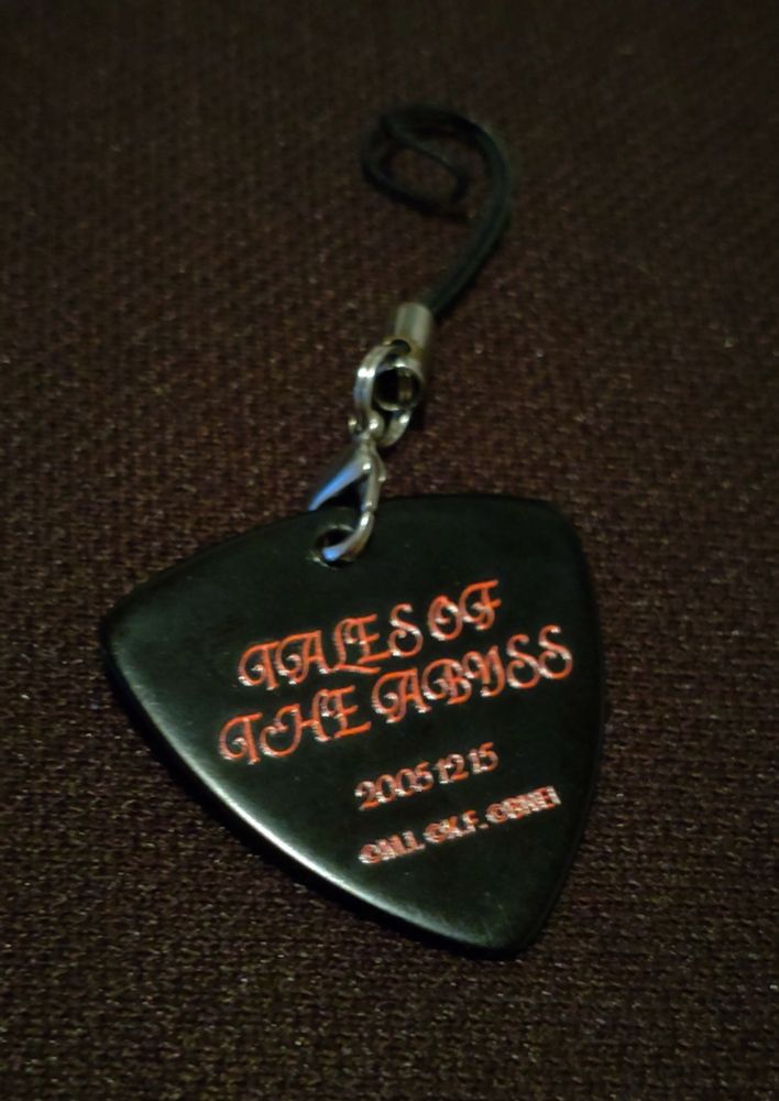 The back side of the same charm. The text says Tales of the Abyss 2005.12.15