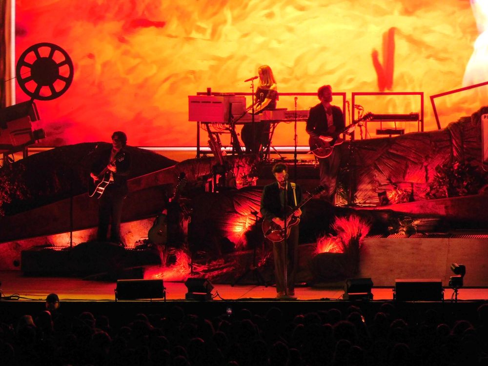 A band on different parts of a stage lit orange 