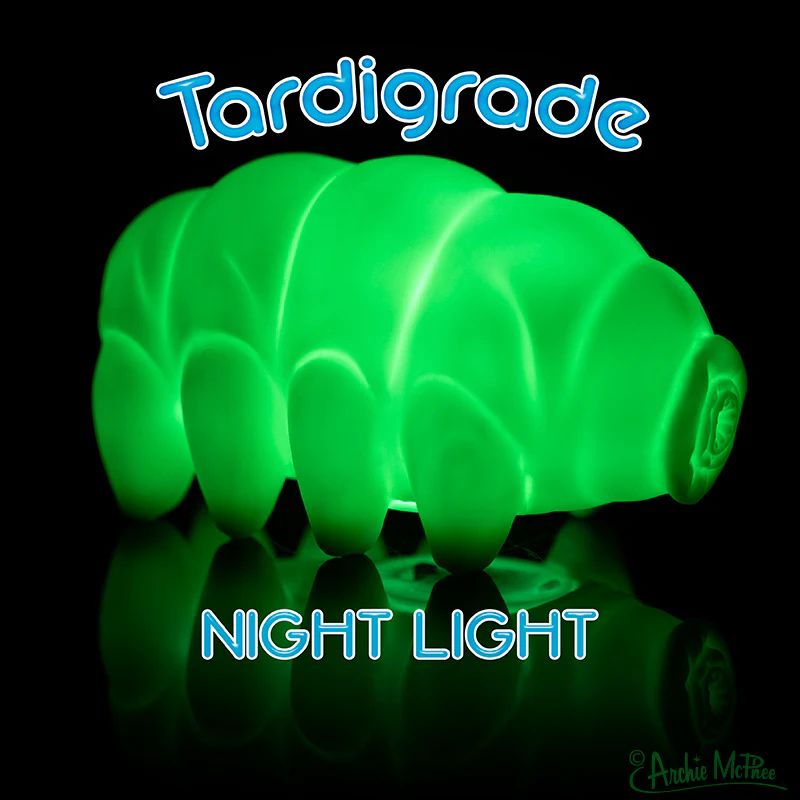 A glowing green tardigrade night light is displayed against a black background. The text "Tardigrade NIGHT LIGHT" is featured prominently.