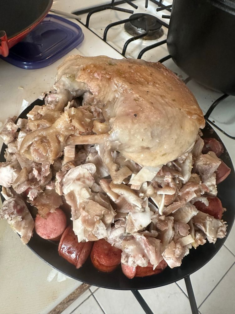 A large platter of meat for a cassoulet, chunks of polish sausage, two duck legs confit, pork rib meat, salt pork, chopped simmered pigs ears, boned and chopped trotters, heaped in a towering pile. 