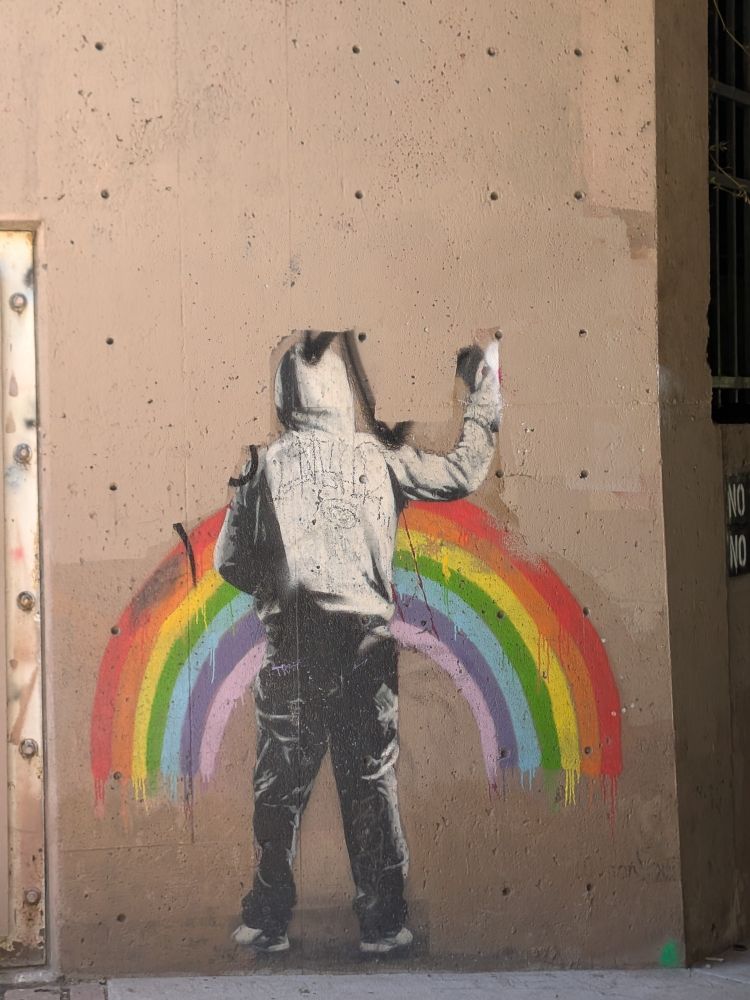 Wall mural of a person standing in front rainbow!