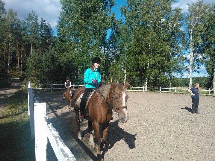 Me at 13-14 raising in outdoor arena, next to a forest 