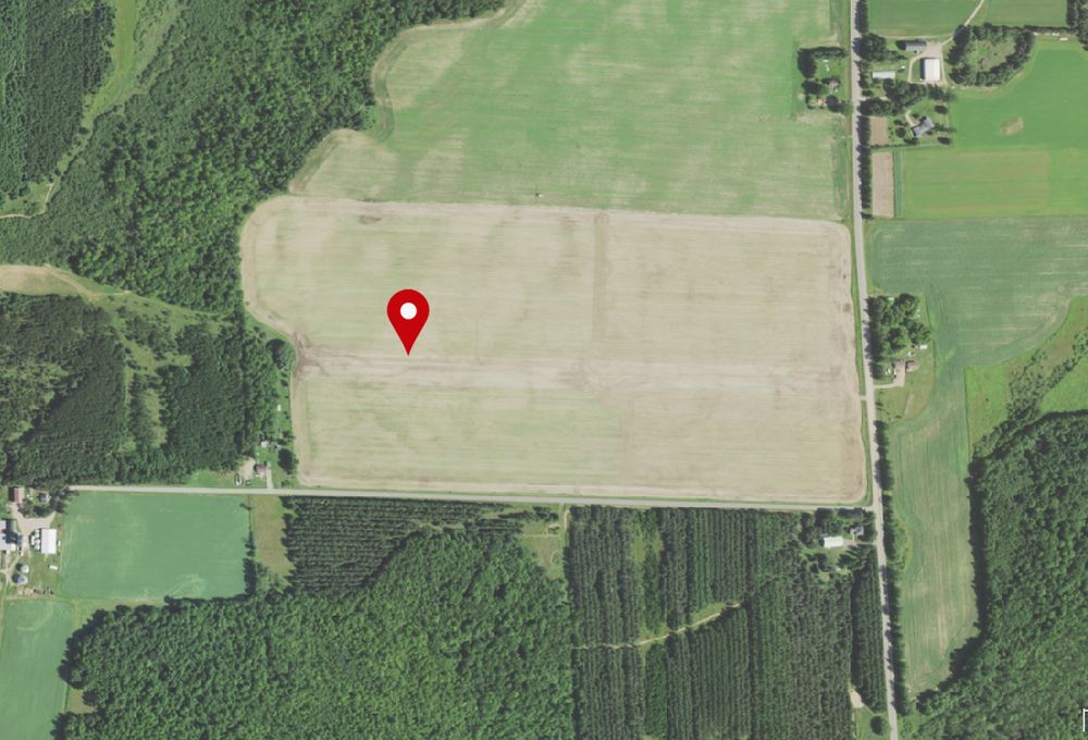 An air photo from 2022. Fields have been merged into much larger units. An area that was a field is now probably a pine plantation. The same farmsteads are still there.