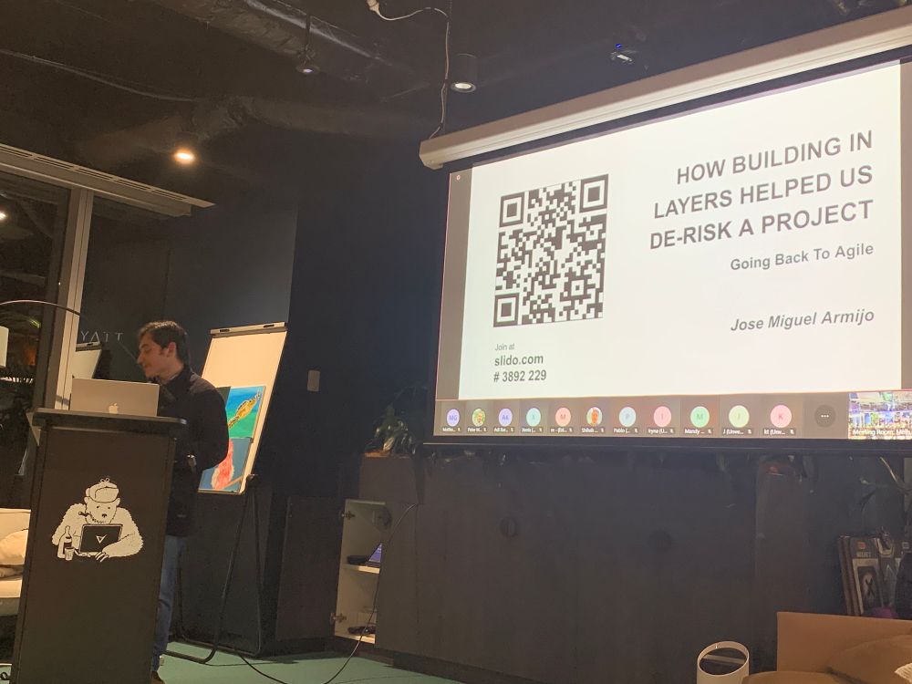 Jose Miquel Armijo presents with a presentation slide titled "How building in layers helped us de-riak a project"