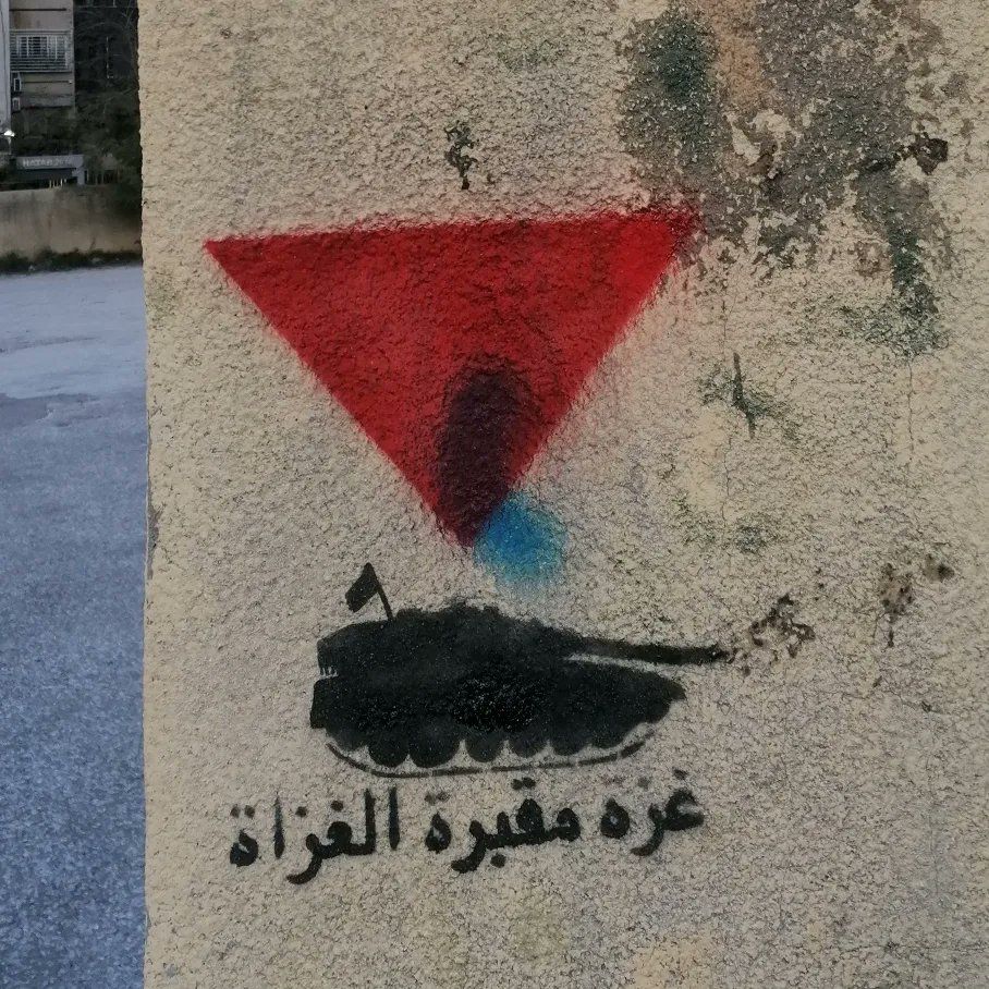 Street graffiti of a red triangle pointing down at a Merkava

"Gaza - Graveyard of Invaders" translated from Arabic