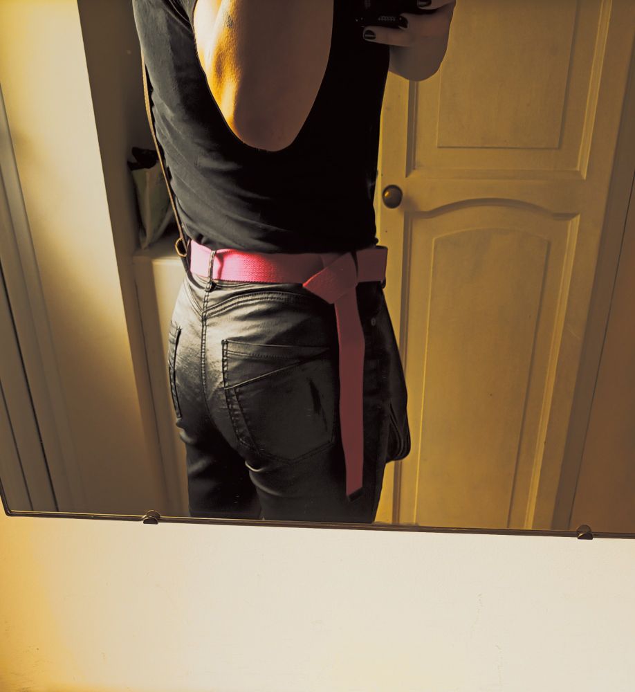 Over the shoulder shot of my ass looking worse in the photo than it did IRL. Still looks pretty damn great tho, ngl, in black faux leather pants with a pink belt