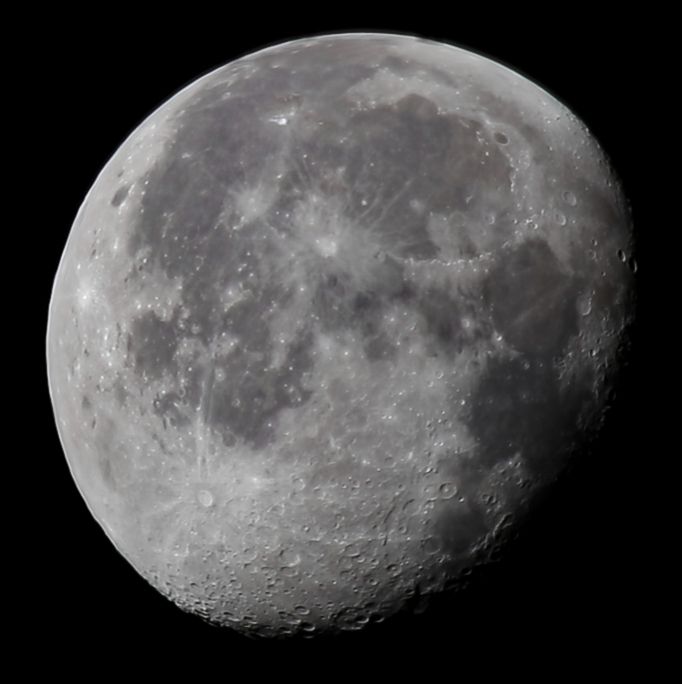 A close up image of our Moon in a waning gibbous phase (Between Full phase and 3/4 full). Also taken on the morning of 8-12-25.
Many craters are visible along the right side of the Moon where the shadow is advancing after being at Full Moon phase. Large dark, roughly circular areas known as "mare" (or "seas") dominate a large portion of the visible surface. They are places filled with ancient cooled lunar lava. Several large craters with bright rays of ejected material are visible. The background of space is black from high contrast with the bright surface of the Moon.