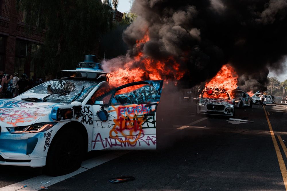 Waymo vehicles covered in graffiti and set on fire in Los Angeles.