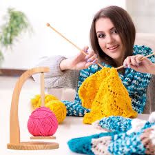 Woman trying to look like she’s knitting by poking knitting needles awkwardly into a finished piece of knitting.