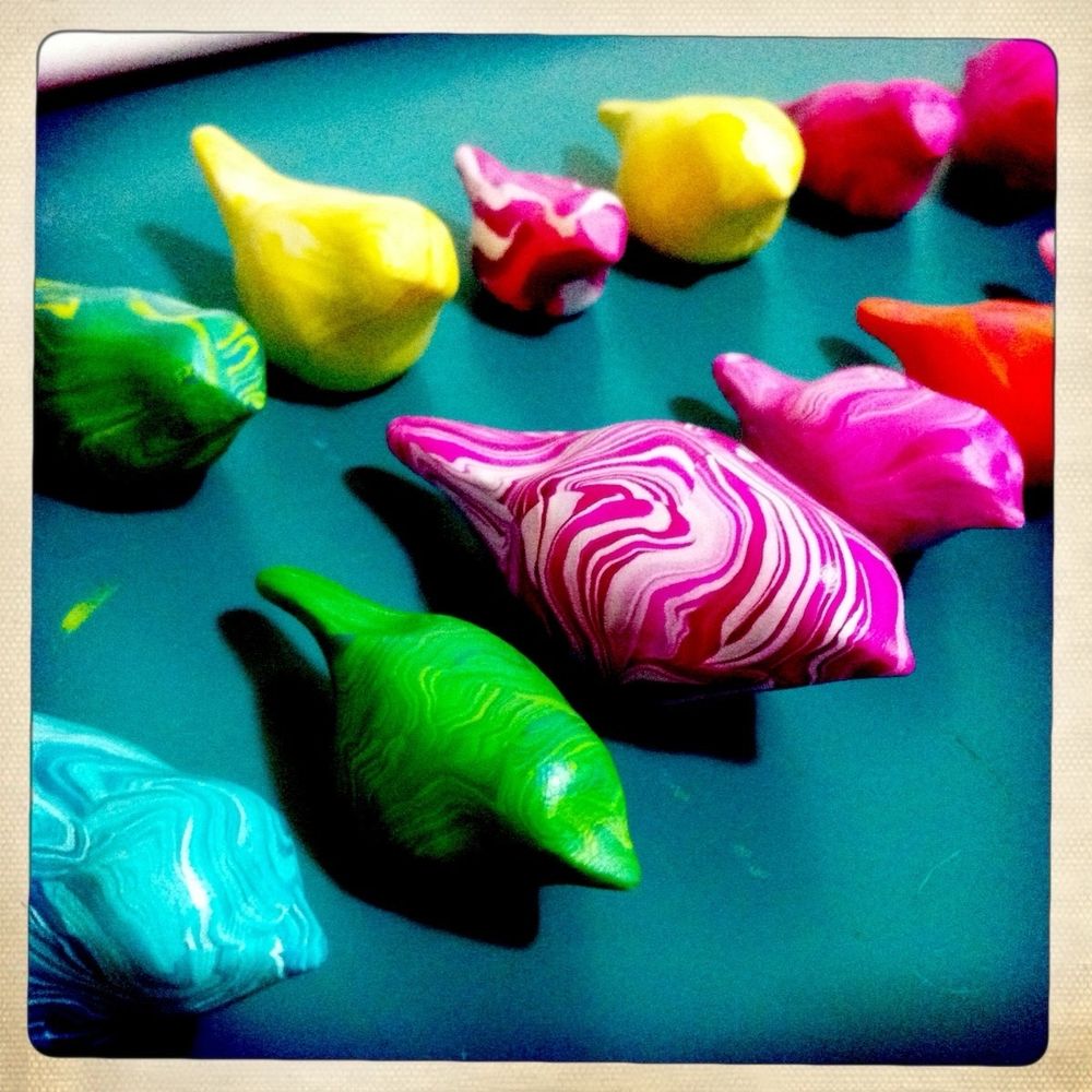Brightly colored bird sculptures made with marbled polymer clay