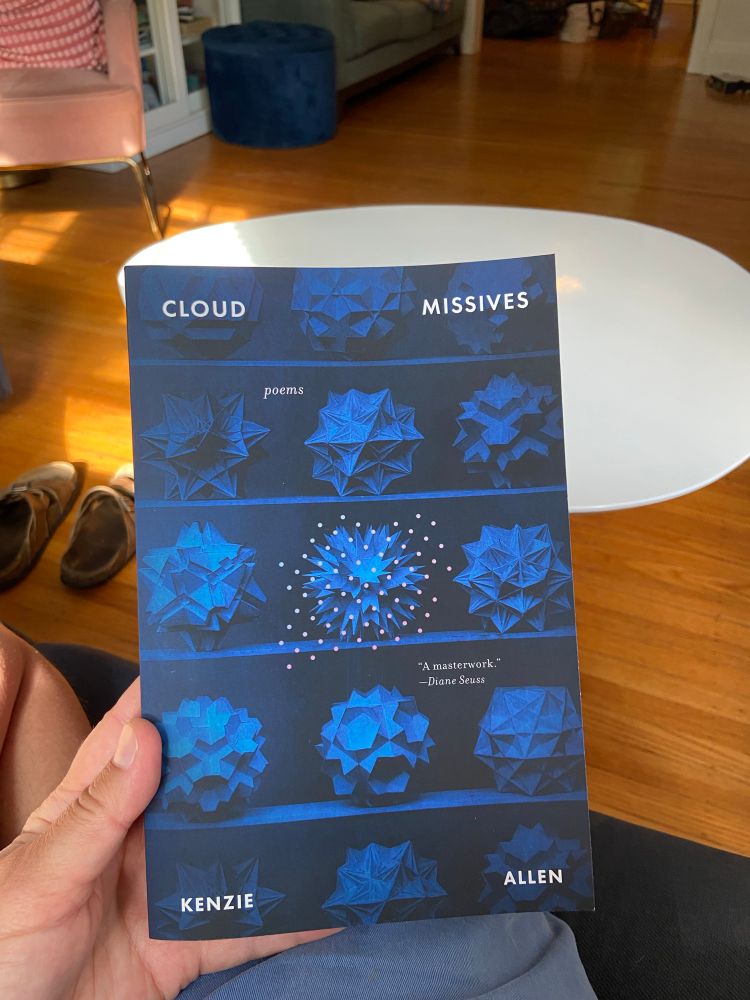A hand holding Cloud Missives by Kenzie Allen