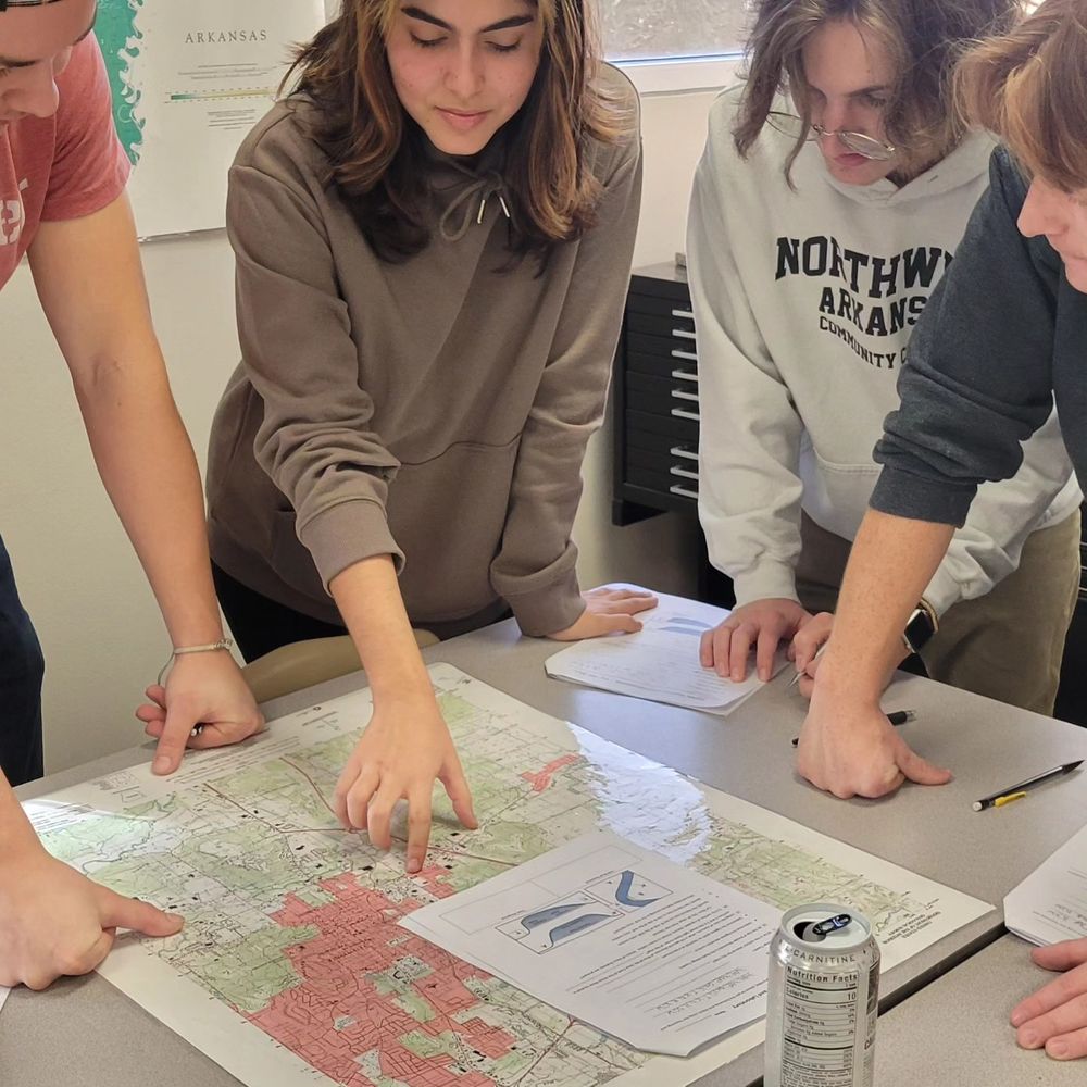 Team of adult learners discussing and interpreting map information. 