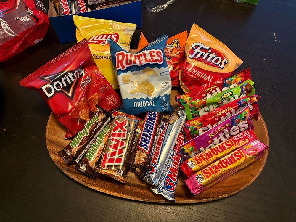 Halloween treats ready for trick or treaters: Doritos, Lays, Ruffles, Cheetos, Fritos, Milky Way, Twix, Snickers, 3 Musketeers, Starburst, and Skittles. The candy is all full size. 