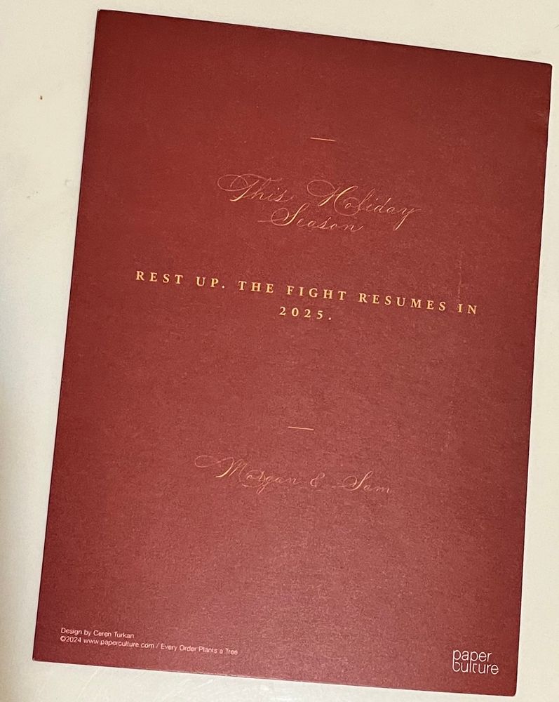 A photo of the reverse of the card. The text reads: "This Holiday Season Rest Up. The fight resumes in 2025. - Morgan & Sam"

At the bottom are credits: "Design by Ceren Turkan ©2024 paper culture www.paperculture.com/Every Order Plants A Tree"

