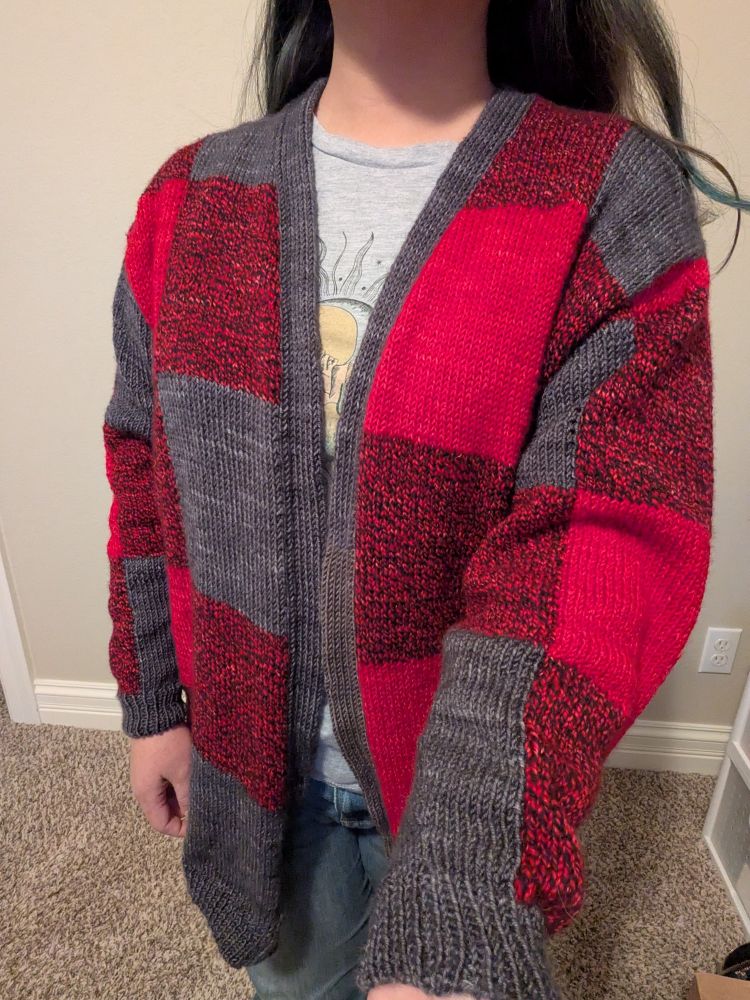 Showing off the front of the Caladium Cardigan, which is a plaid like pattern in red and gray