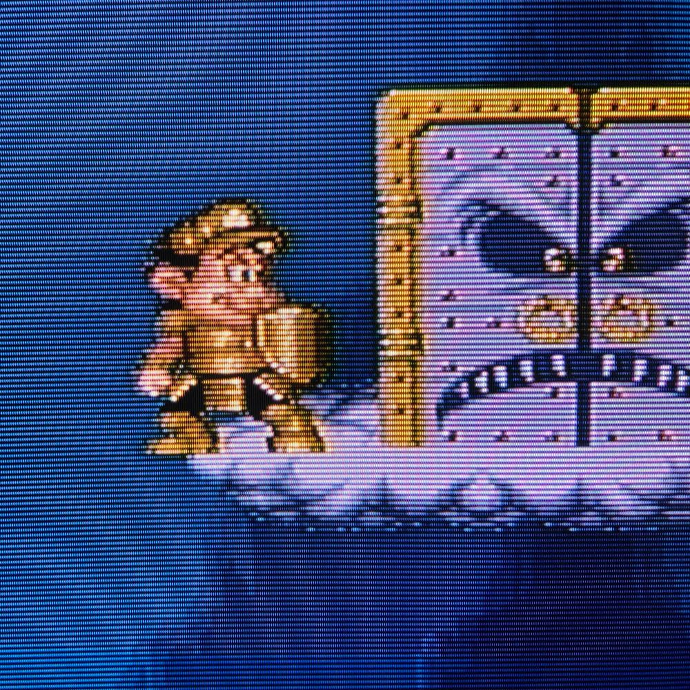 Close up photo of Master Higgins wearing the Light Armor and carrying the Light Shield just before the door to the final boss of the the Super Nintendo (SNES) game Super Adventure Island II on a Sony WEGA KV-27FS120 CRT television.