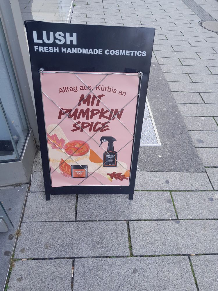 Lush-Werbeständer in der Fußgängerzone. Beworben werden Produkte "Mit Punpkin Spice" unter dem Motto "Alltag aus, Kürbis an".