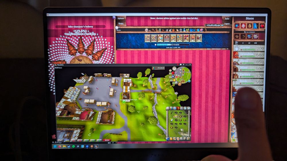 Sanjan with thumbs up with RuneScape + cookie clicker on the laptop screen 