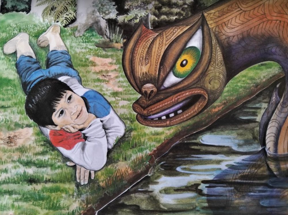 A boy in sweatshirt, baggy pants and gumboots lies on the grass and smiles up at his ancient friend and guide, the taniwha, in the water beside him.