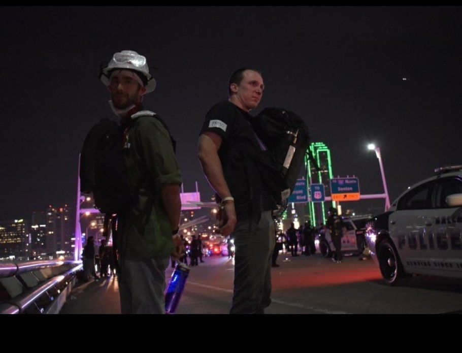 A photo of Steven and his assistant in restraints after being detained while reporting on a protest in Dallas in 2020 that was kettled and attacked by police 