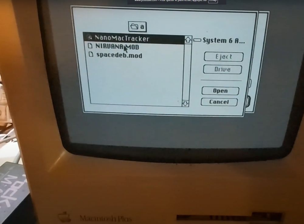 picture of a Mac Plus with a file dialog that shows 3 items: the program NanoMacTracker, NIRVANA.MOD and spacedeb.mod

the buttons on the dialog say: Eject, Drive, Open and Cancel.

the first item is highlighted in black