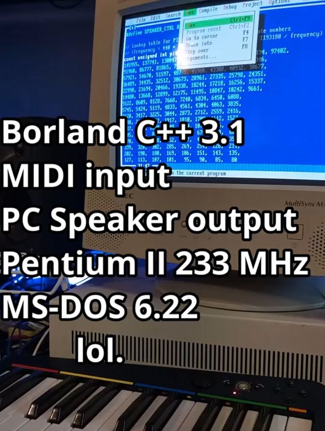 a beige CRT is showing Borland C++ 3.1 running in msdos with its classic blue and gray user interface. Some C code is showing on screen.