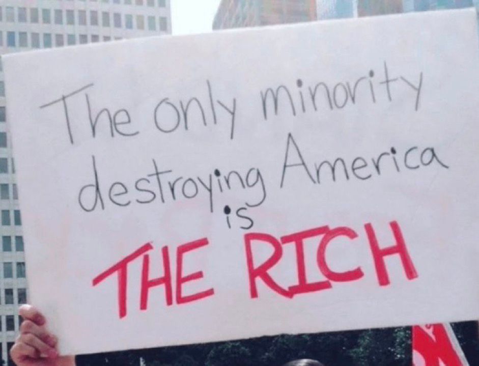 A protest sign saying “The only minority destroying America is The Rich”