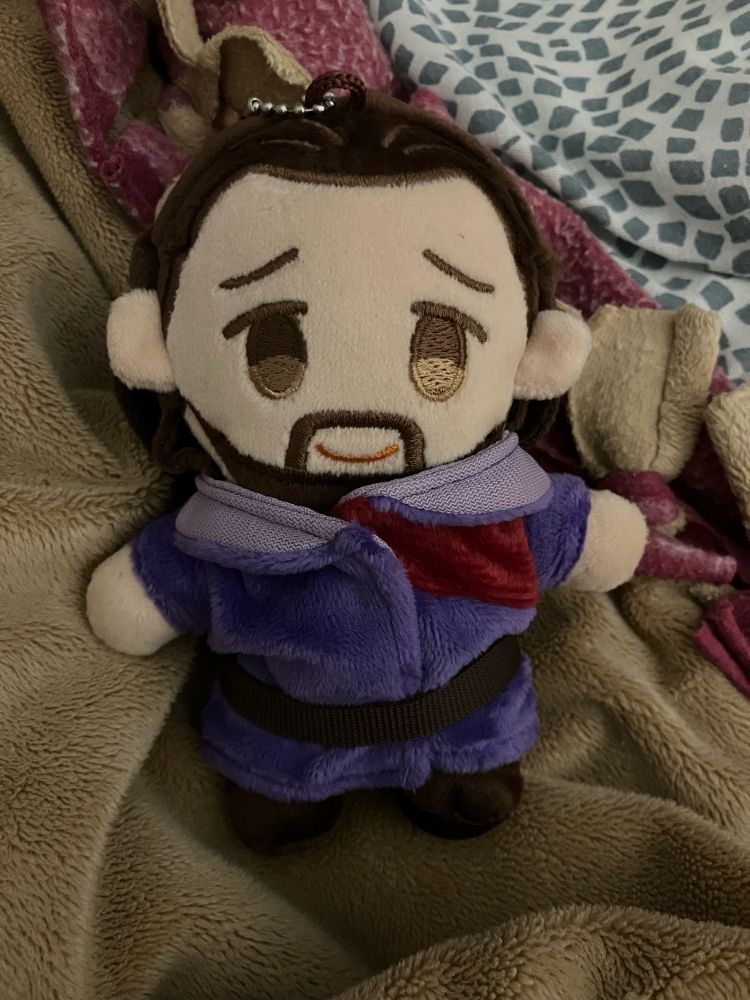 A photo of a small plushie version of Gale from Baldur's Gate 3