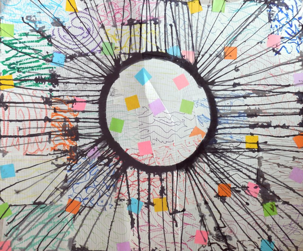 Colorful abstract collage of various types of paper surrounding ring of black of ink, with drips radiating outwards.