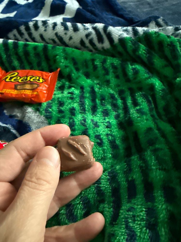 The World’s Smallest Snickers which is in a hand. It is roughly the size of a quarter. Maybe. 