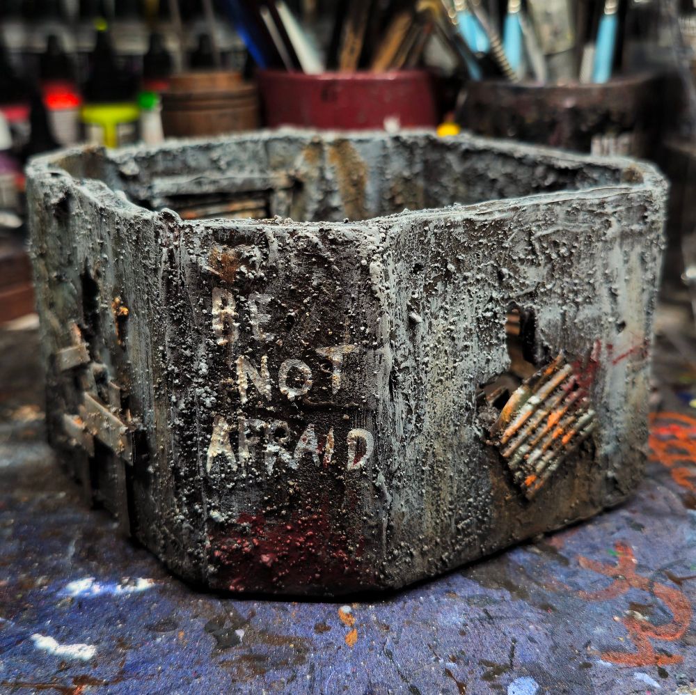 A third angle of the bunker, focusing on a bloodstain and graffiti that reads "be not afraid"
