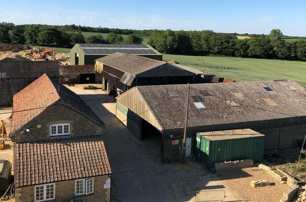 A yard in the UK is an area with a hard surface, typically surrounded by buildings and often commercial in nature. 