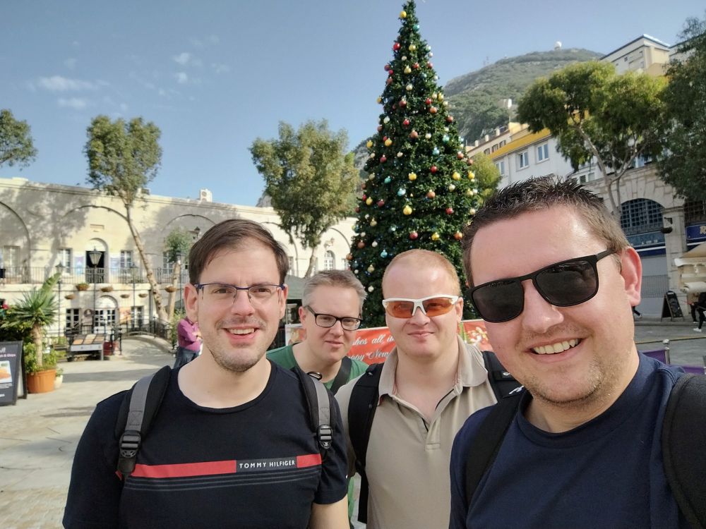 Four fine male specimens standing in front of a Christmas Tree at Casemates Square, Gibraltar.