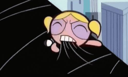 a cartoon character from the powerpuff girls is laying on a black surface .