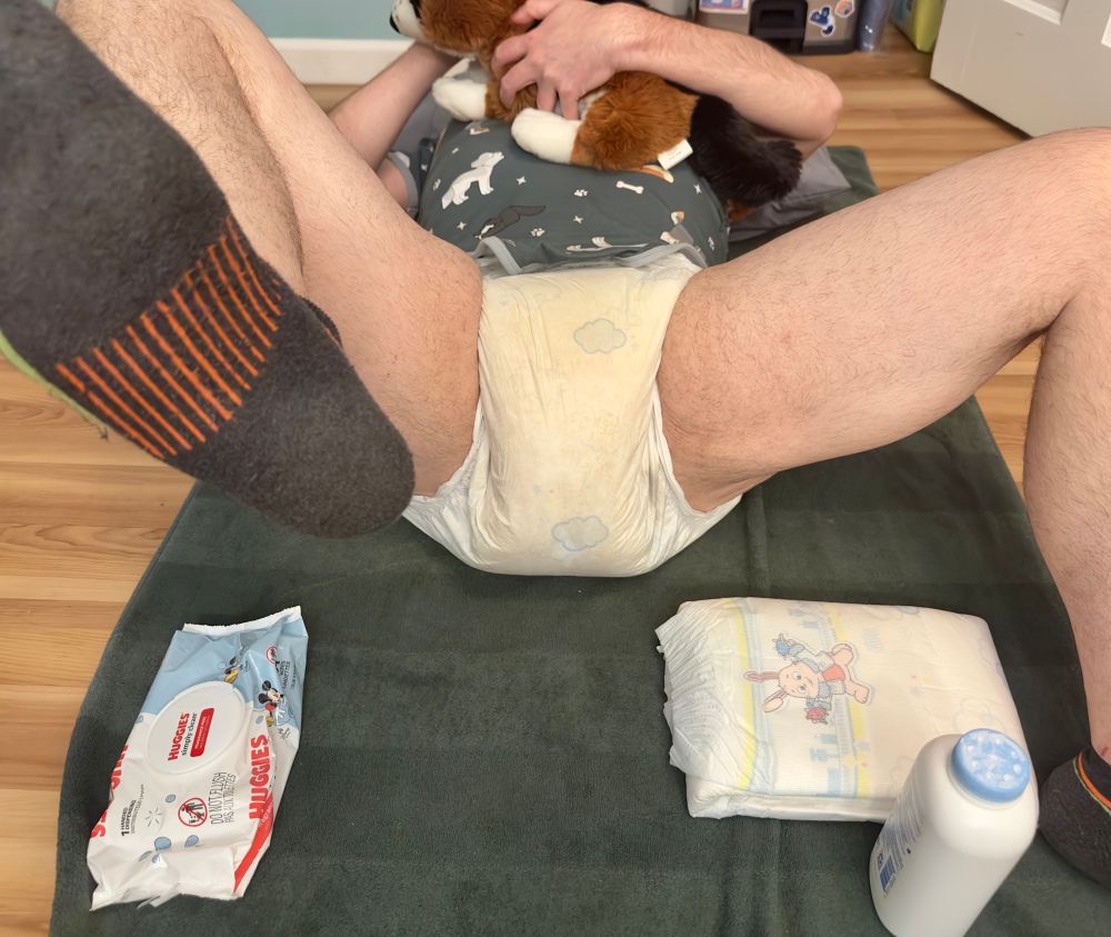 changing scene, I’m laying on my back in a messy diaper